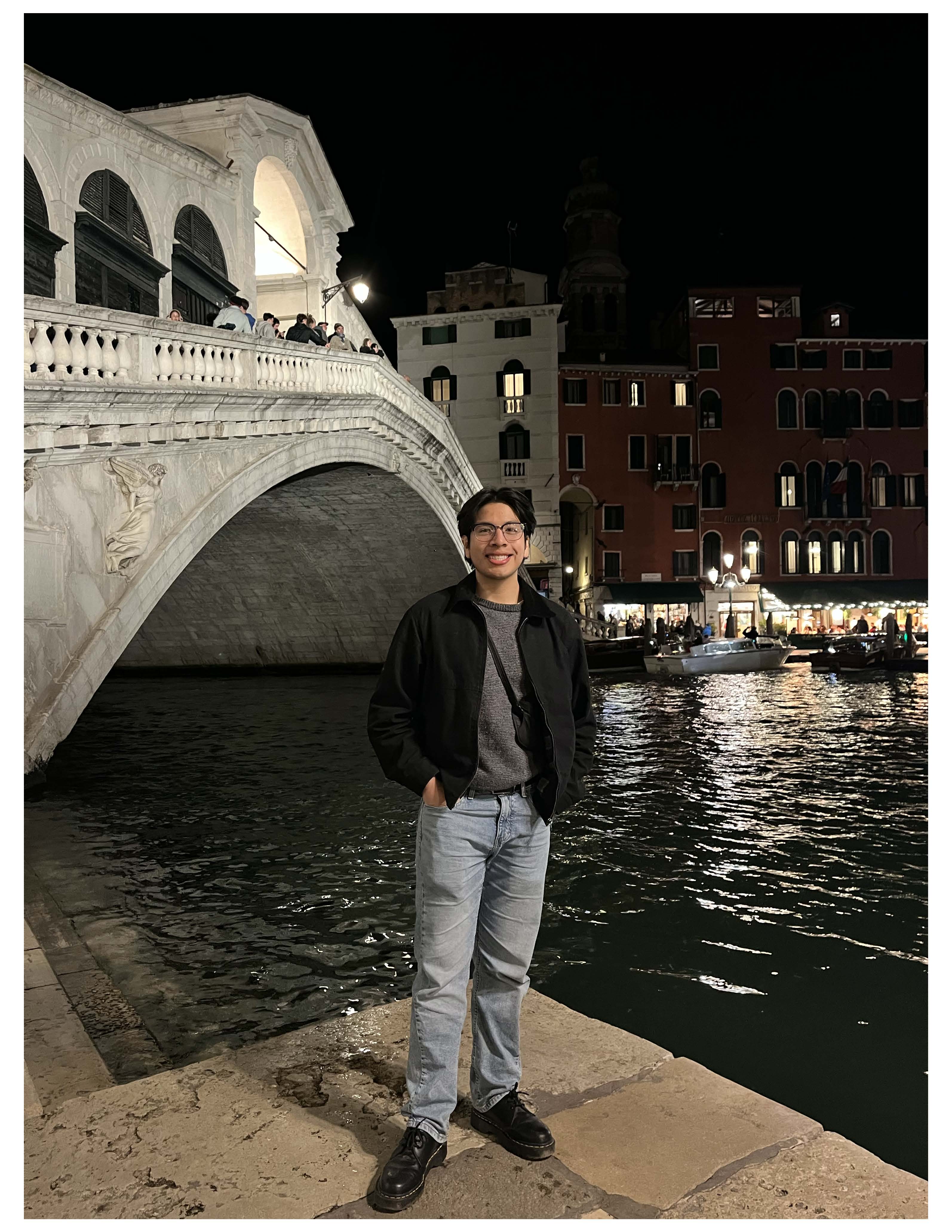 Leonardo in front of Venice's Rialto Bridge. The charming night lights on in the background!