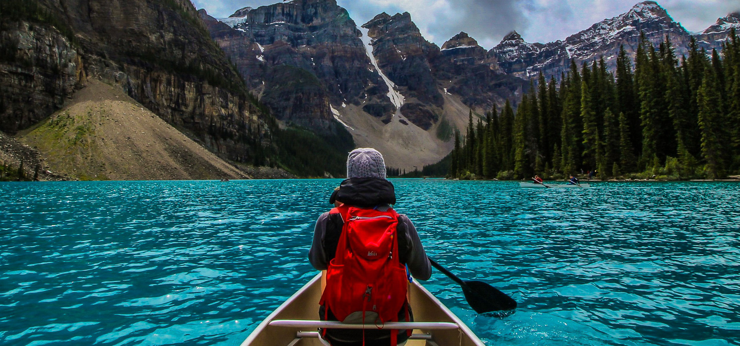 Woman canoeing on the turquoise water of Moraine Lake in Banff National Park, Canada