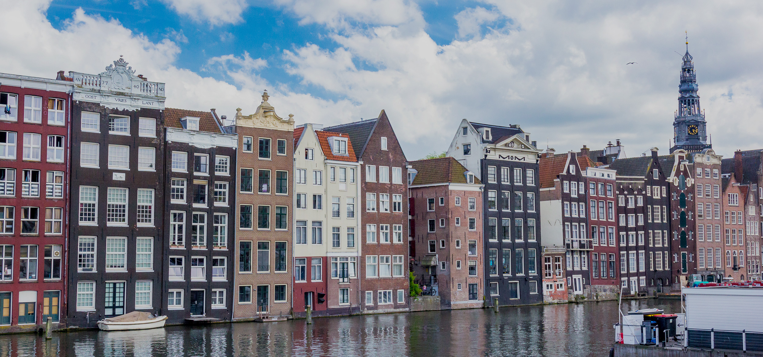 Colorful row of old Dutch houses reflected in a canal in Amsterdam in the Netherlands